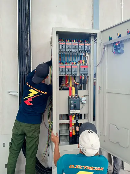 Teknisi listrik sedang memasang panel SDP pabrik