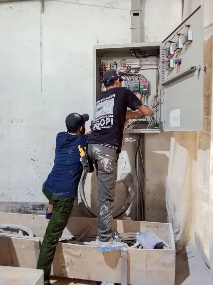 Teknisi listrik sedang melakukan perbaikan panel SDP pabrik