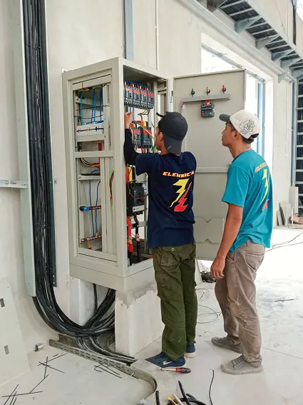 Teknisi listrik sedang memasang panel SDP pabrik