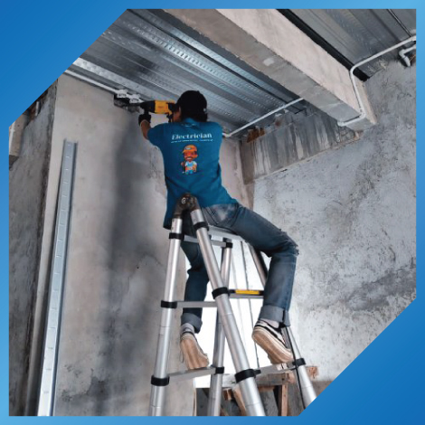 Tukang listrik sedang memasang instalasi listrik gedung